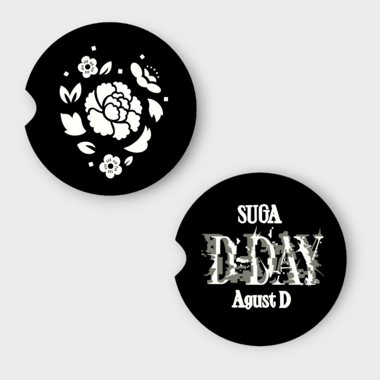A set of black round Car Coasters with a divit on the left site. One coaster has Flowers and the other reads Suga D-Day Agust D.