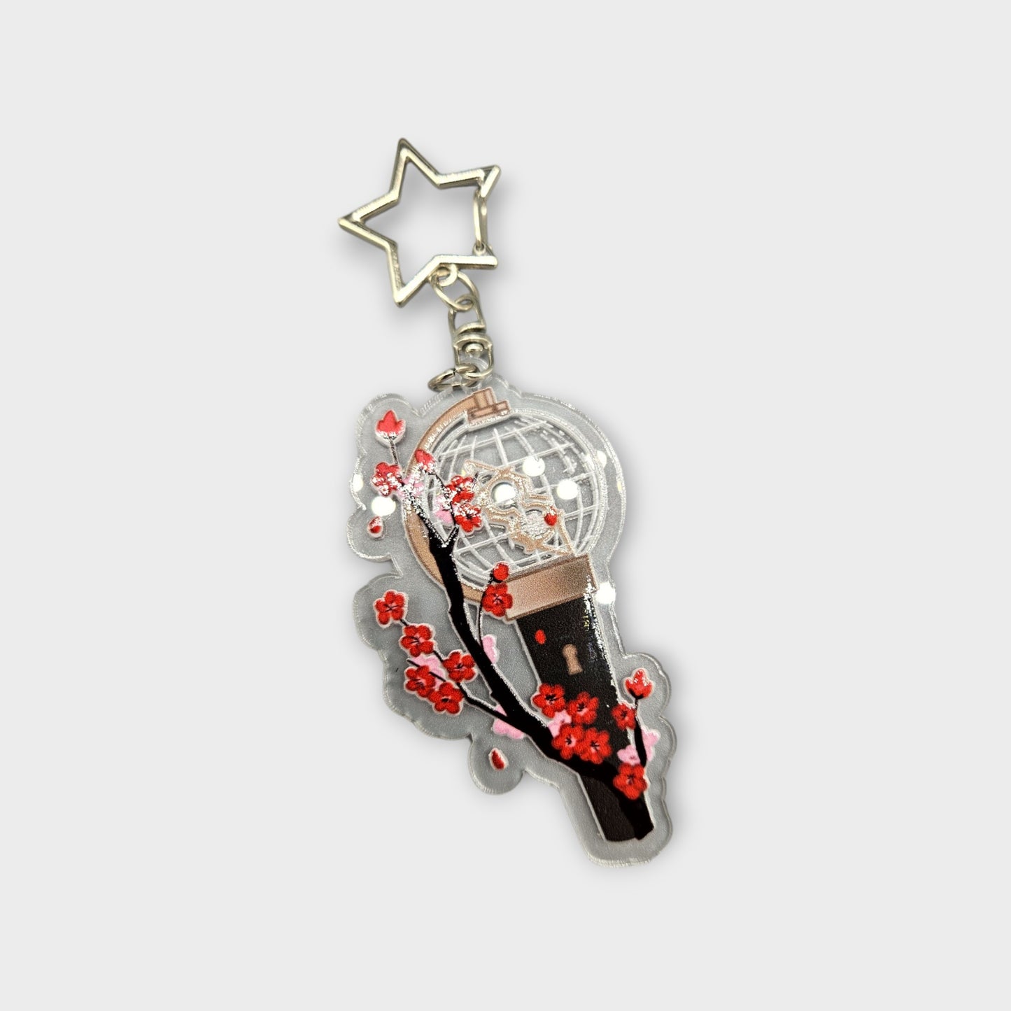 A Clear acrylic Keychain with a picture of Ateez' lightstick with Plum blossoms around it.