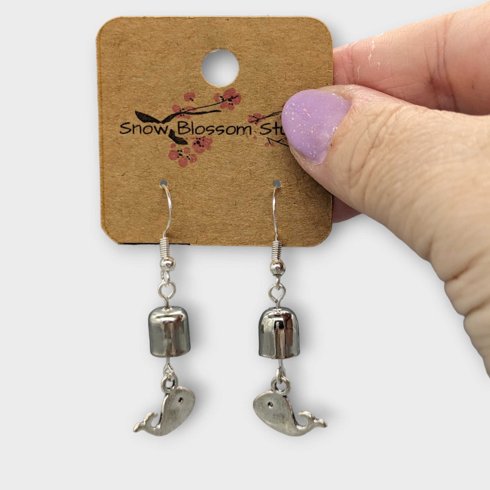 Earrings with a whale and a bell.