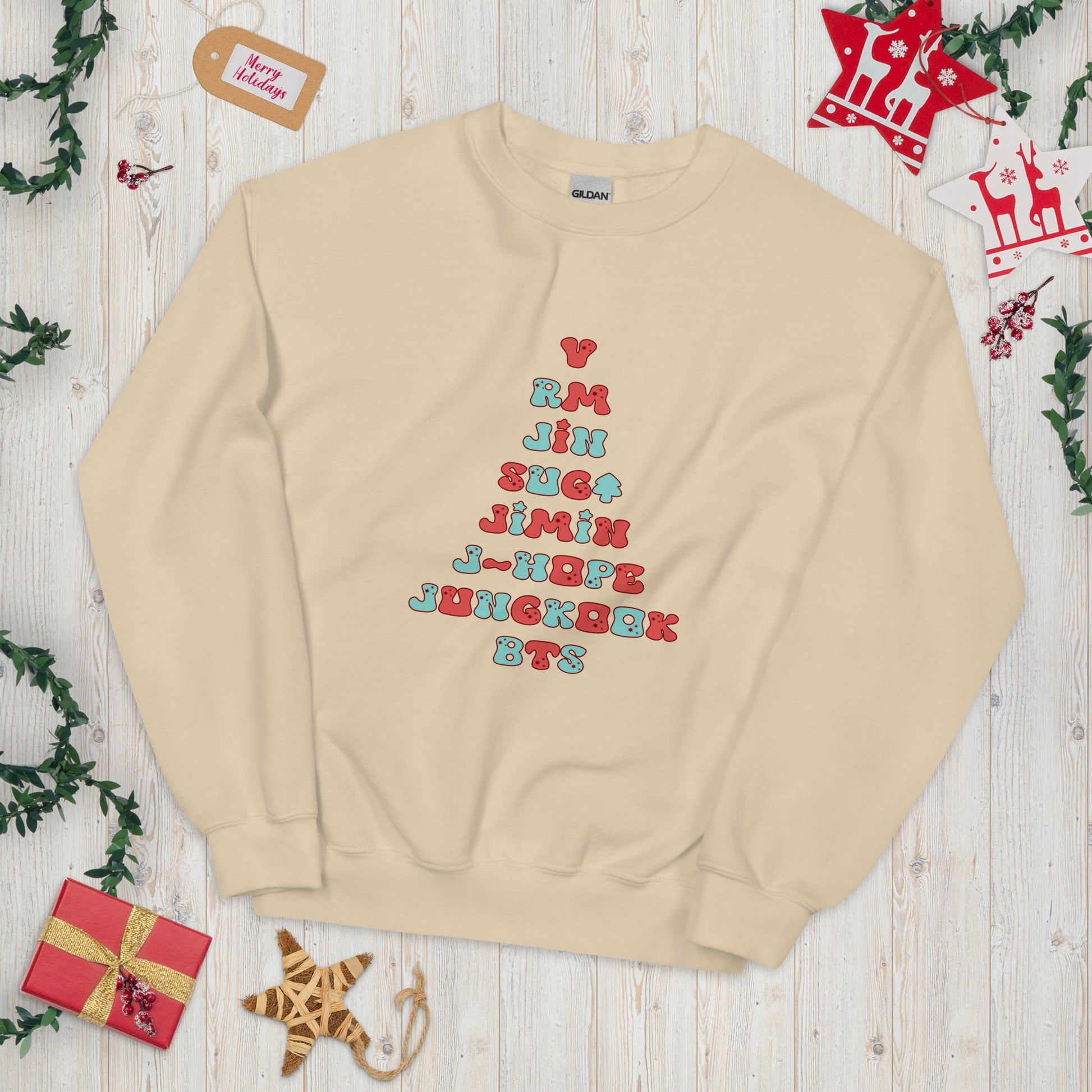 Tan Sweatshirt with all 7 names of BTS arranged to make a Christmas Tree shape. 