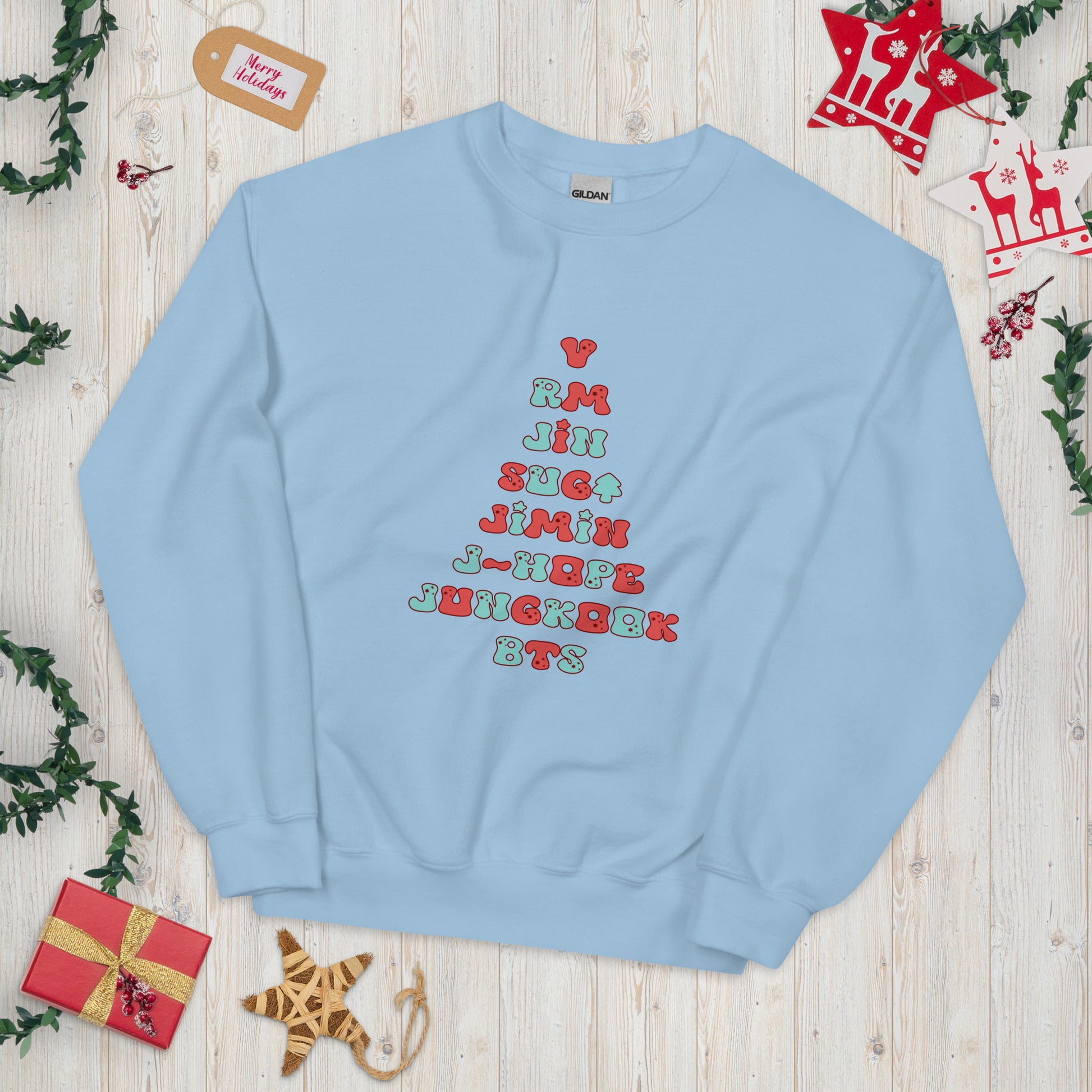 Baby Blue Sweatshirt with all 7 names of BTS arranged to make a Christmas Tree shape. 